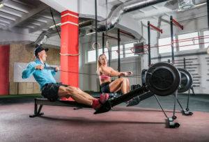 Man and Woman Rowing on Indoor Rowing Machines