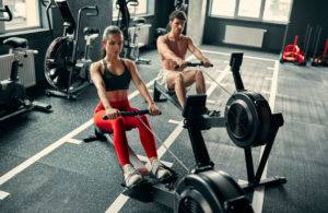 Couple Working Out on Indoor Rowing Machines