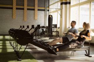 Man and Woman rowing on Rowing Machines