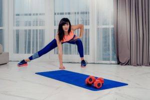 female crouched down over yoga mat