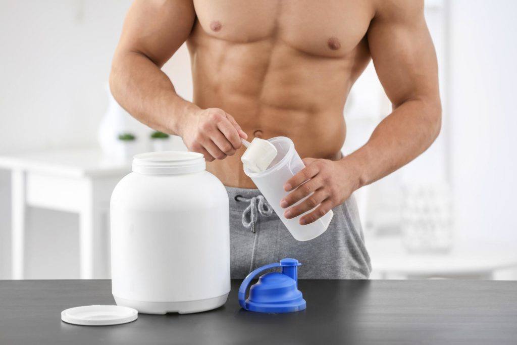 male adding protein powder to cup