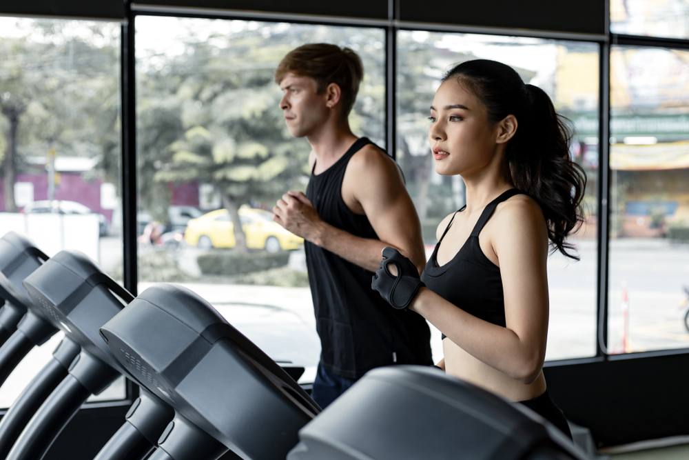 male and female running on treadmill