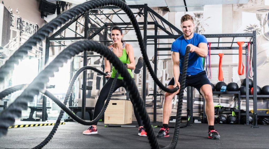 male and female using cross fit ropes