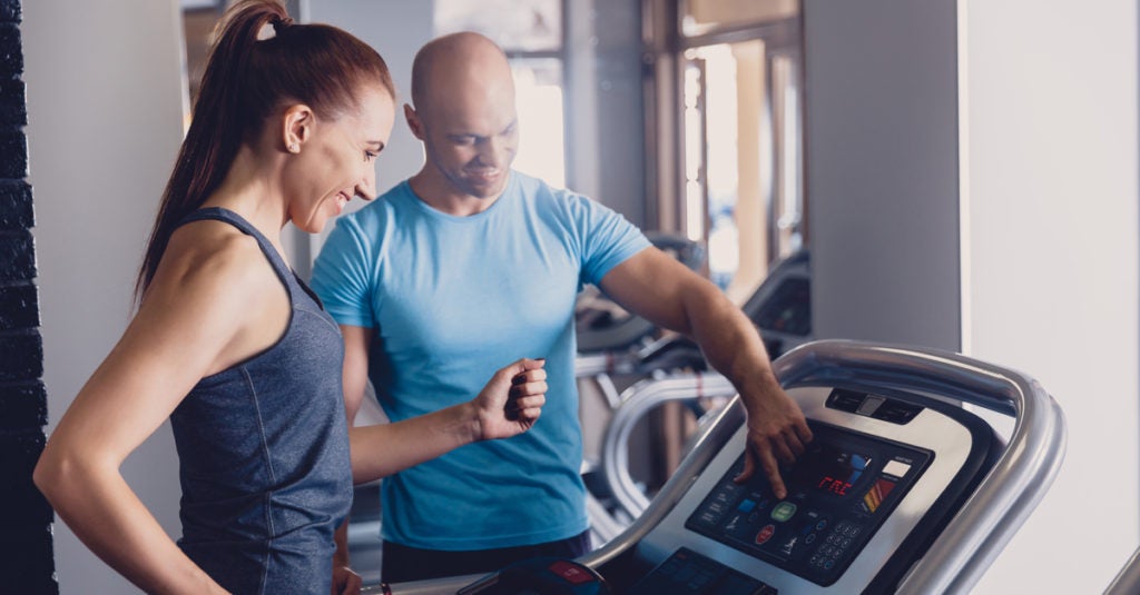 Woman with trainer on treadmill