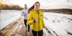 Woman and man running outside in the winter