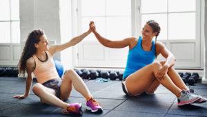 2 women high-fiving at gym