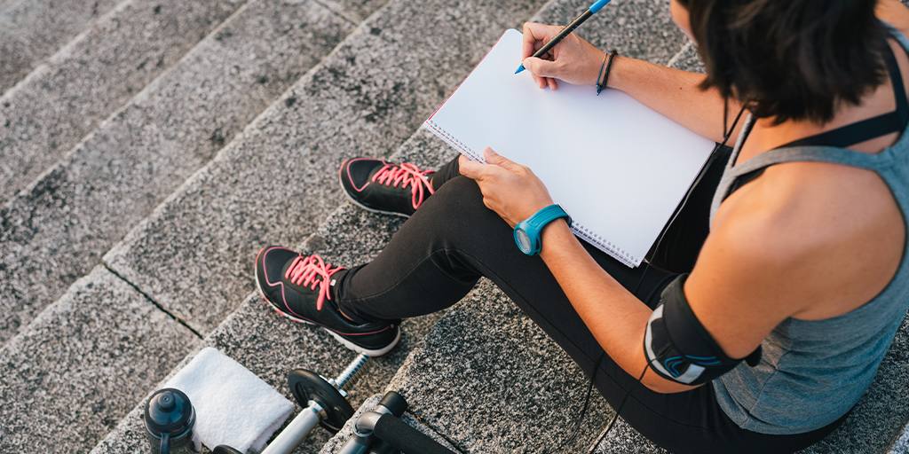 Woman writing fitness goals